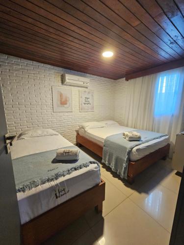 two twin beds in a room with at Charme do Chalé 17 em Gravatá in Gravatá