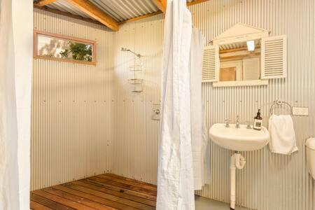 een badkamer met een wastafel en een wit douchegordijn bij Kilara Cottage 3-Bed 2-Bath in Cowes