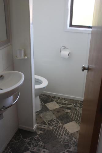 a bathroom with a toilet and a sink at Esplanade Townhouse in Gisborne