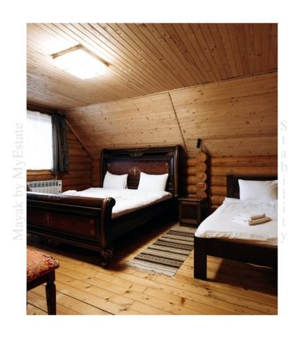 um quarto com 2 camas num chalé de madeira em Mayak Chalet Resort Mykulychyn em Mykulychyn