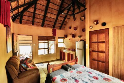 a kitchen with a couch and a table in a room at Hyenas Call in Marloth Park