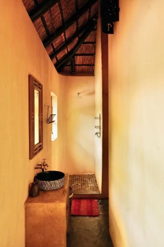 a bathroom with a sink and a mirror on the wall at Hyenas Call in Marloth Park