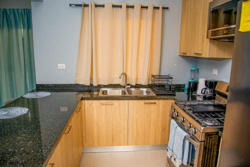 a kitchen with a sink and a stove at Beautiful Village 3 bedrooms Furnished Pool residencial Velero punta cana in Punta Cana