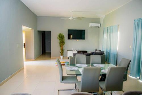 a dining room and living room with a table and chairs at Beautiful Village 3 bedrooms Furnished Pool residencial Velero punta cana in Punta Cana
