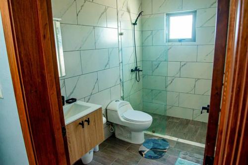 a bathroom with a toilet and a sink and a window at Beautiful Village 3 bedrooms Furnished Pool residencial Velero punta cana in Punta Cana
