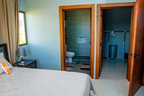 a bedroom with a bed and a bathroom with a toilet at Beautiful Village 3 bedrooms Furnished Pool residencial Velero punta cana in Punta Cana
