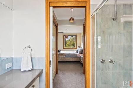een badkamer met een douche en een slaapkamer met een bed bij Private Family Home Near North-Facing Beach in Cowes