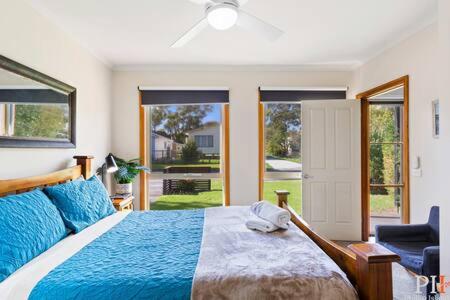 een slaapkamer met een bed, een stoel en ramen bij Private Family Home Near North-Facing Beach in Cowes