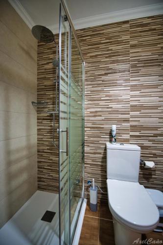 a bathroom with a toilet and a glass shower at Waves of Tranquility Residence in San Miguel de Abona