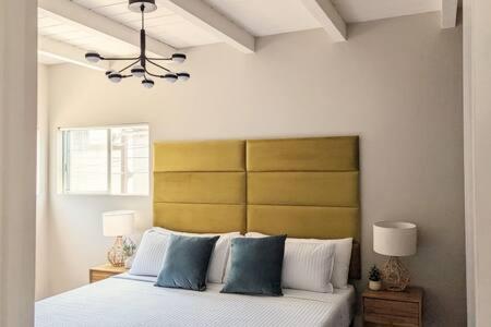 1 dormitorio con 1 cama grande con almohadas azules en Beachside Bliss Oceanview Apt in Manhattan Beach, en Manhattan Beach