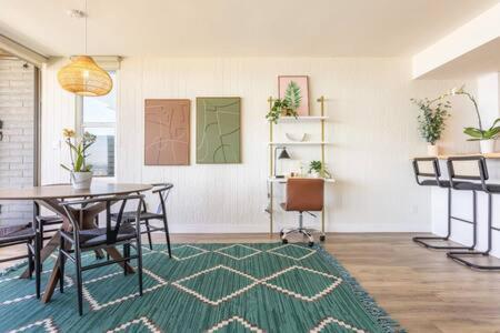 a dining room with a table and a green rug at Manhattan Beach as your Backyard The Strand in Manhattan Beach