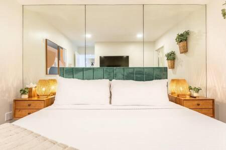 a bedroom with a large white bed with a green headboard at Manhattan Beach as your Backyard The Strand in Manhattan Beach