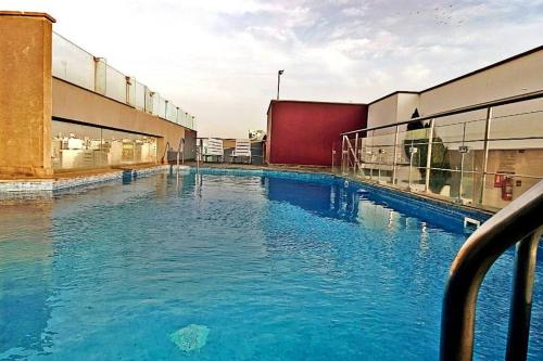 a large pool of blue water in a building at Excellent apartment, access to pool, grills, ballroom in Lima