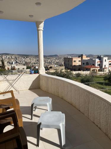 a balcony with two chairs and a view of a city at Jerash Heart in Jerash