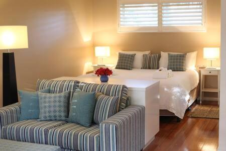 sala de estar con cama y sofá en Driftwood - Luxury Spa Cottage for Two, en Cowes