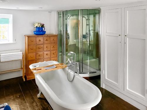 a bathroom with a tub and a glass shower at Bradley Hall in Stanton in Peak