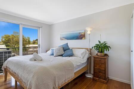 a white bedroom with a bed and a window at Kookaburra Hideaway 4-Bed 2-Bath in Cowes