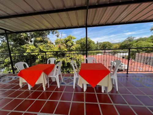 two tables and white chairs on a balcony with a view at Hotel Colonial Villavieja in Villavieja