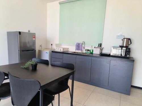 a kitchen with a table and chairs and a refrigerator at New 2BR or 3BR Homey Getaway stay 7 to 10 pax at Urban Suites, Georgetown by URBAN STAYCATION LOD in Jelutong