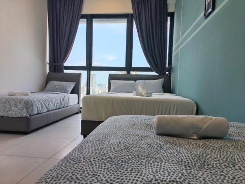 a bedroom with two beds and a large window at New 2BR or 3BR Homey Getaway stay 7 to 10 pax at Urban Suites, Georgetown by URBAN STAYCATION LOD in Jelutong