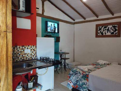 a kitchen with a sink and a bed in a room at Chalé de Charme MANDOMAI - Suítes com Cozinha Compacta, Suítes com Cooktop e Chalé com Cozinha in Ilhabela