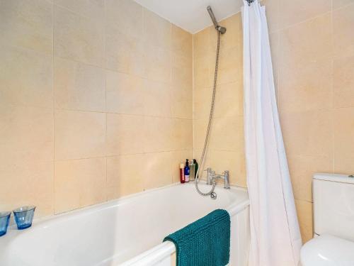 uma casa de banho com banheira e cortina de chuveiro em Seaside Retreat em Bognor Regis
