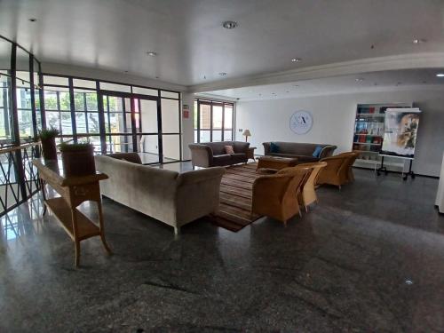 a living room with couches and tables and windows at Saint Martin By Escala Imóveis in Fortaleza
