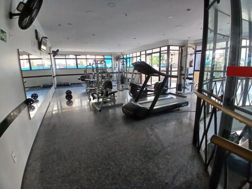 a gym with cardio equipment in a building with windows at Saint Martin By Escala Imóveis in Fortaleza
