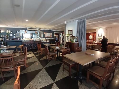 a restaurant with tables and chairs and a bar at Saint Martin By Escala Imóveis in Fortaleza