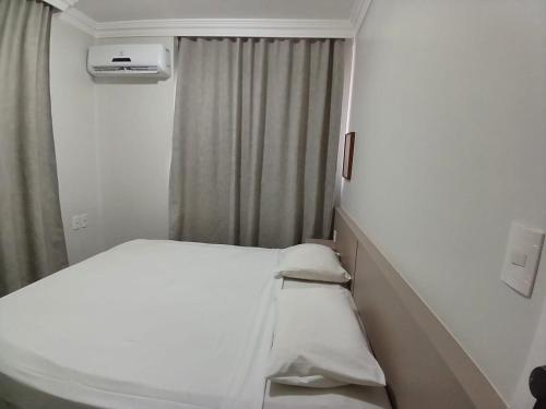 a small room with a bed and a window at Saint Martin By Escala Imóveis in Fortaleza