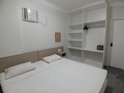 a white bedroom with a bed and a fan at Saint Martin By Escala Imóveis in Fortaleza