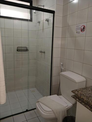 a bathroom with a toilet and a glass shower at Saint Martin By Escala Imóveis in Fortaleza