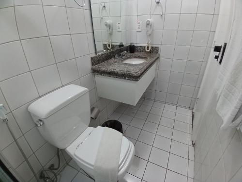 a white bathroom with a toilet and a sink at Saint Martin By Escala Imóveis in Fortaleza