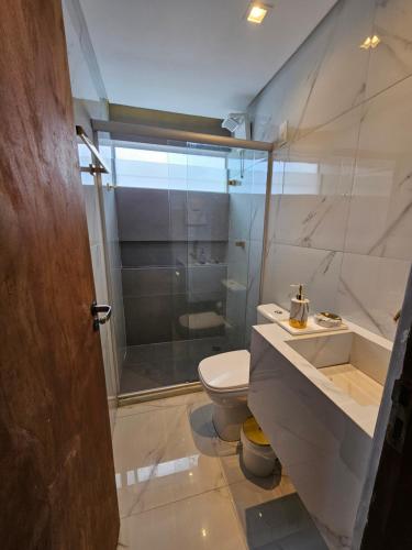 a bathroom with a shower and a toilet and a sink at Charme do Chalé 17 em Gravatá in Gravatá