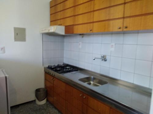 a small kitchen with a sink and a stove at Saint Martin By Escala Imóveis in Fortaleza