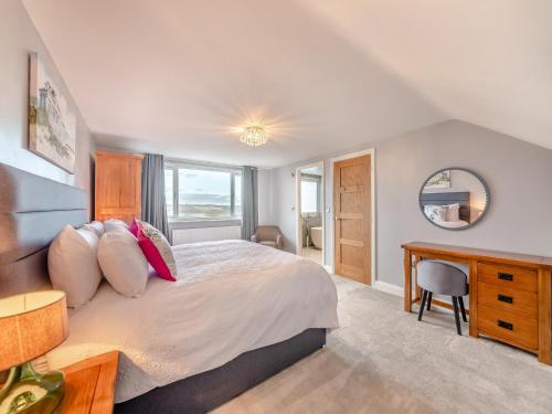 a bedroom with a bed with a desk and a mirror at Wynmine Cottage in Esh