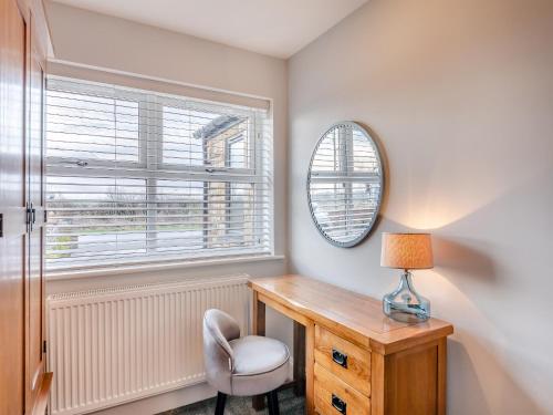 a room with a table and a chair and a mirror at Wynmine Cottage in Esh