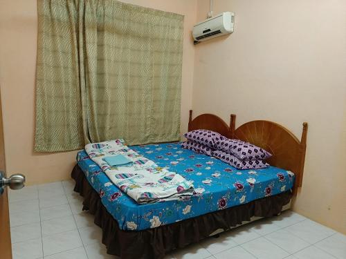 a small bed in a room with a window at Homestay Tengku Maheran in Jitra