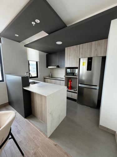 a kitchen with a counter and a refrigerator at Urban Chic Departamento en la Shyris in Quito