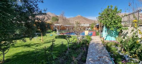 un jardín con piscina y montañas al fondo en Cabañas olmos, en Vicuña