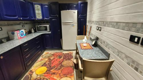 a small kitchen with a table and a refrigerator at 5star apartment View of the Nile and the pyramids on the Nile Corniche in Cairo