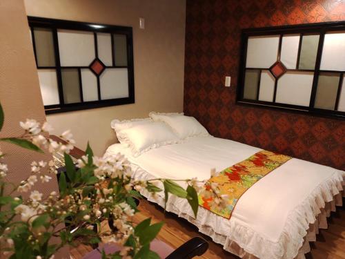 a bed in a room with two windows at 木香Mokkoh Modern Japanese style room by train15 minutes to Tokyo Station in Tokyo