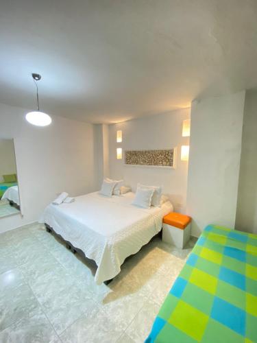 a bedroom with a white bed and a colorful floor at Patio de Getsemani in Cartagena de Indias