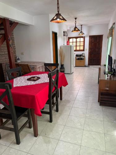 a dining room with a table with a red table cloth at Cabaña en el Centro de Mina Clavero in Mina Clavero