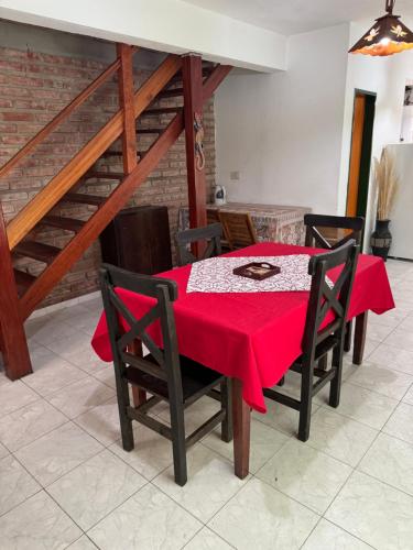 a dining room with a red table and chairs at Cabaña en el Centro de Mina Clavero in Mina Clavero