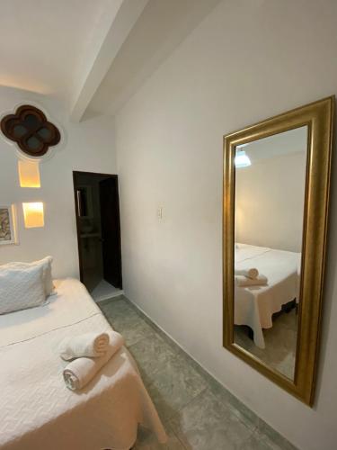 a bedroom with a mirror and a bed and a table at Patio de Getsemani in Cartagena de Indias