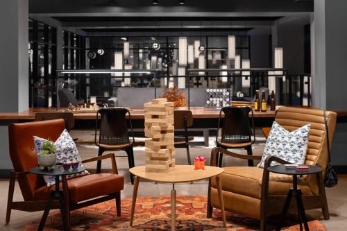 ヒューストンにあるMoxy Houston Downtownのチェスゲーム付きの椅子とテーブルが備わる部屋