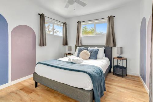 1 dormitorio con 1 cama y 2 ventanas en Modern Family Home w/Pool and Hot Tub, en Atascadero