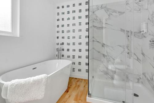 a bathroom with a shower and a white tub at Modern Family Home w/Pool and Hot Tub in Atascadero