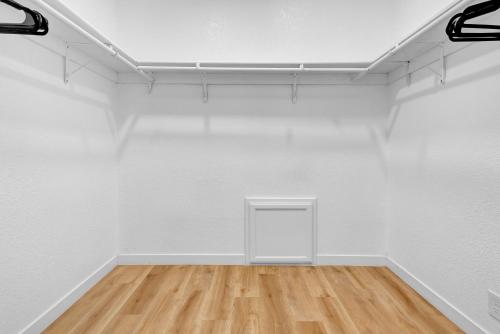 an empty room with white walls and wooden floors at Modern Family Home w/Pool and Hot Tub in Atascadero